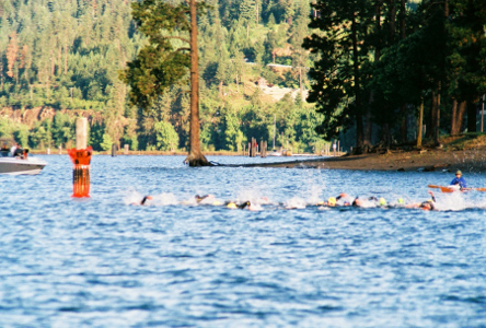 [About a dozen people are in a line of splashing water as a kayaker sits in the background.]